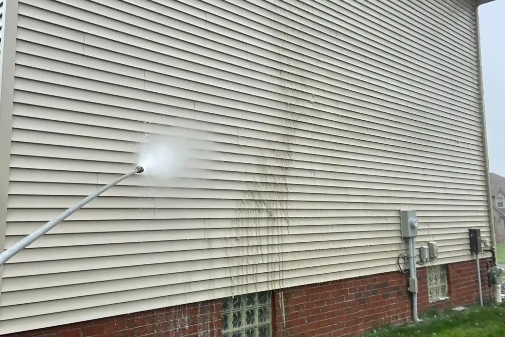 A Person with a Pressure Washer Cleaning a Canfield Home.