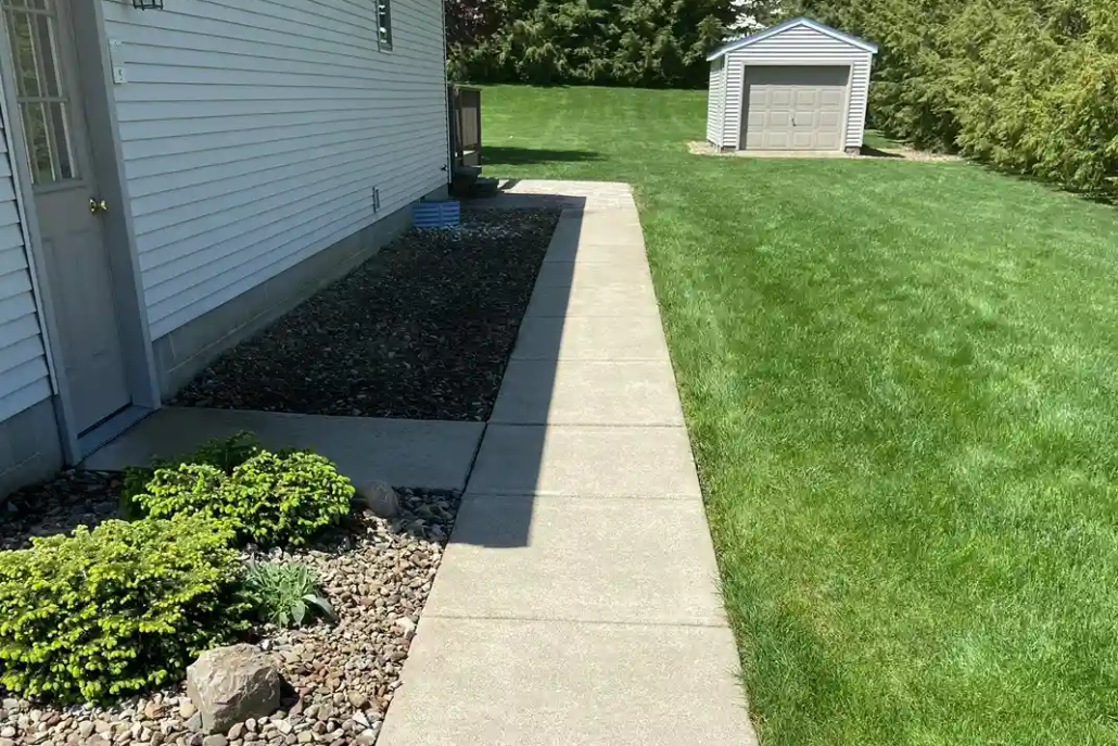 A Bright Sidewalk Shines in the Sun After Being Pressure Washed in Howland.